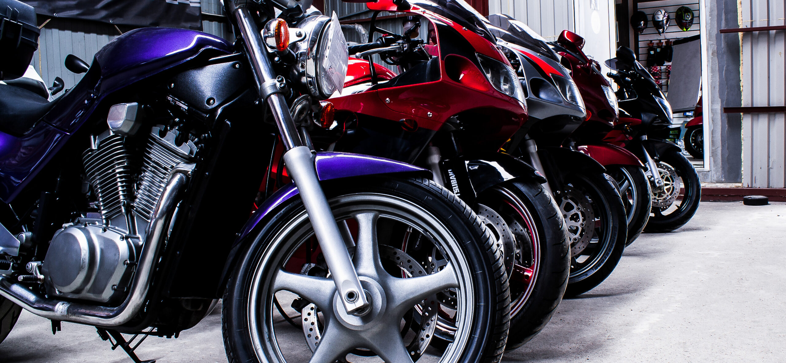 Colored sports, road beautiful bikes in a motor show, close up. Many motorcycles parked in a store. Sale of used cruise motorbikes in the cabin. Showroom equipment in the garage. Banner for web site Colored sports, road beautiful bikes in a motor show, close up. Many motorcycles parked in a store. Sale of used cruise motorbikes in the cabin. Showroom equipment in the garage. Banner for web site